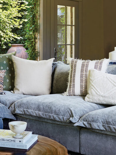 Gray velvet sofa with throw pillows