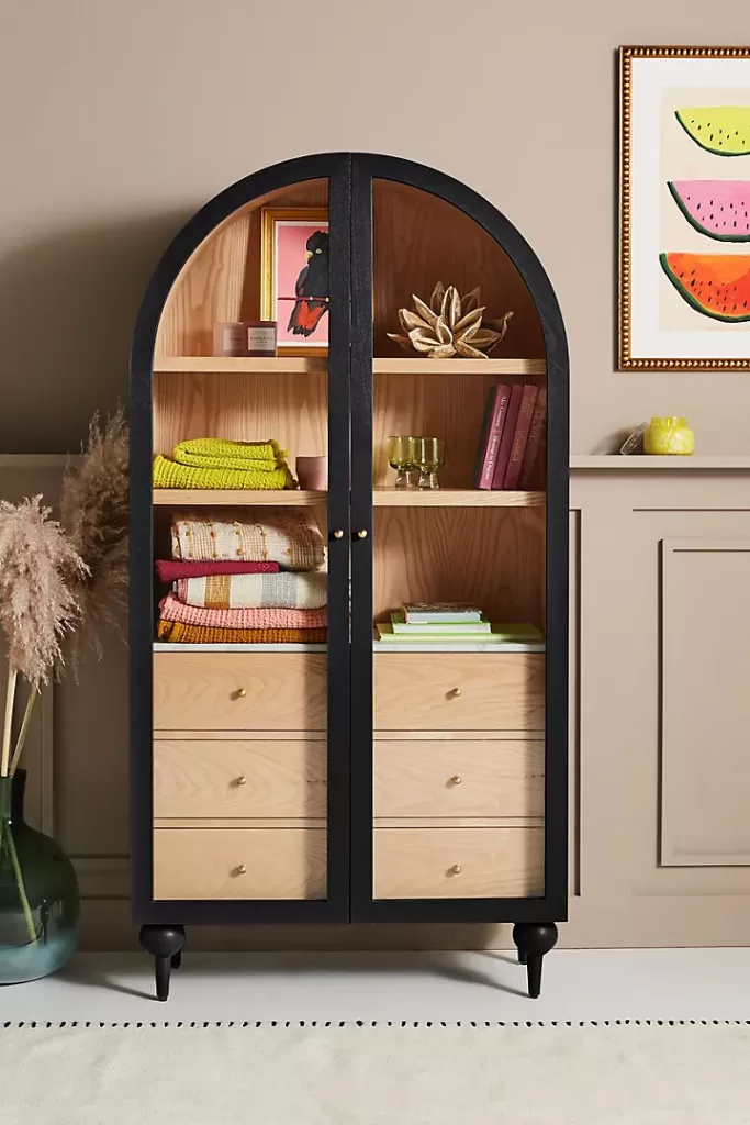 black and wood arched cabinet in a taupe room