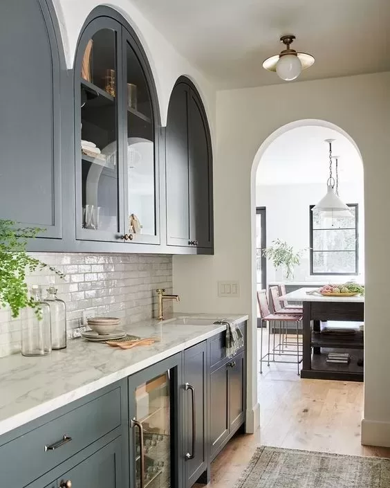 gray arched kitchen cabinets with white backsplash
